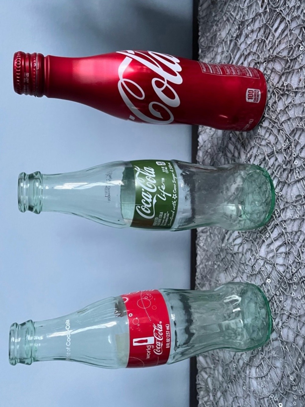 Coca Cola Life Pale Green Glass Bottle, red aluminum bottle and red label bottle